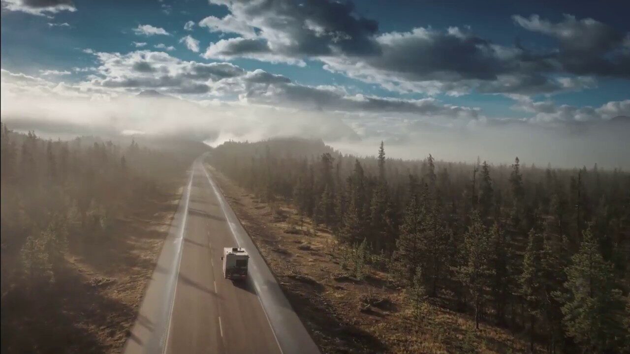 Anteprima del video: un camper su una strada tra i boschi nella nebbia del mattino